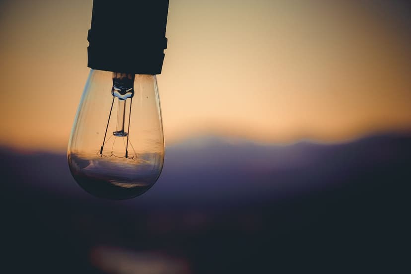 unlit lightbulb with blurred yellow sunset background